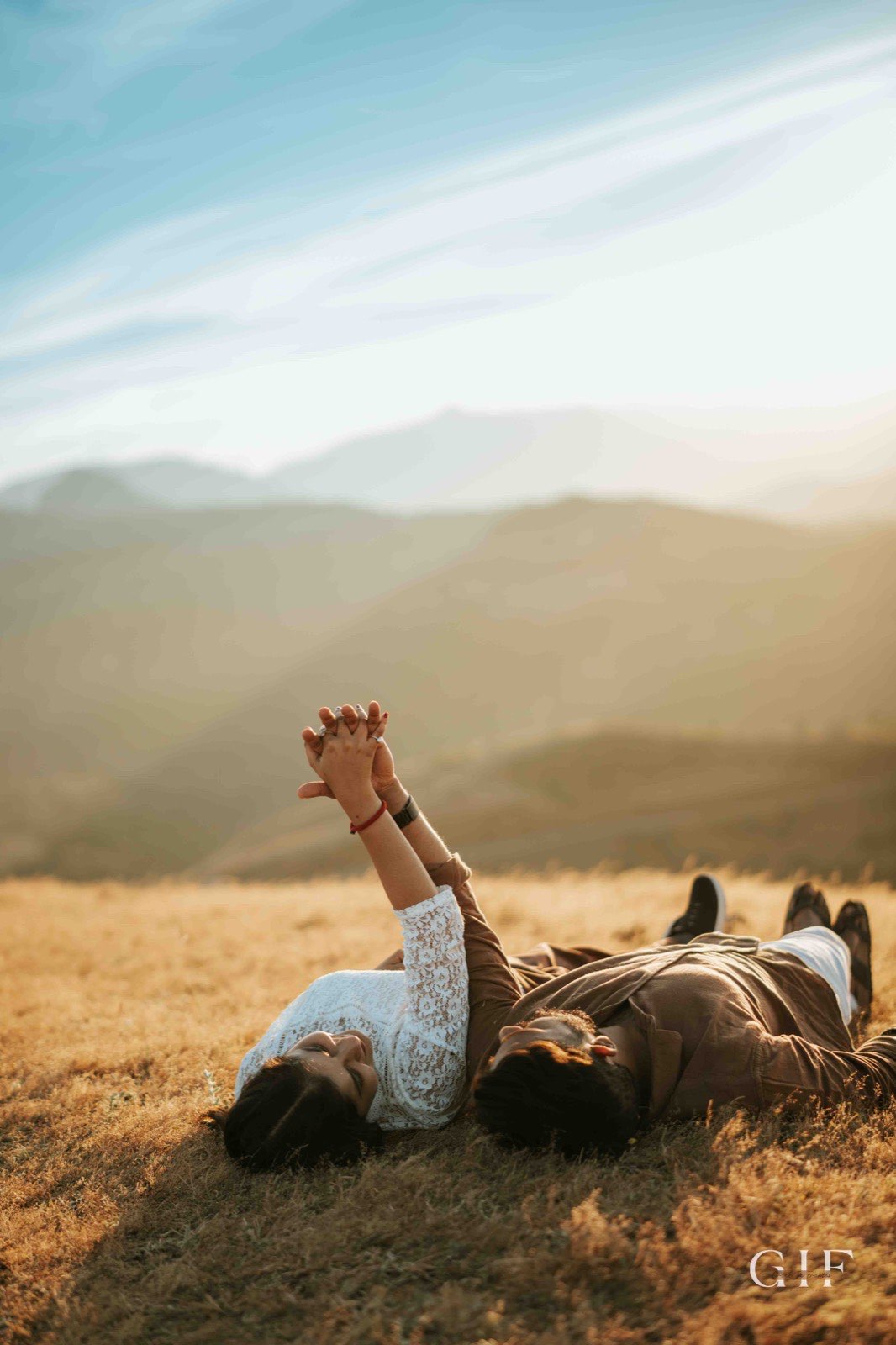 Shreya and Neelesh lying together in a mountain meadow